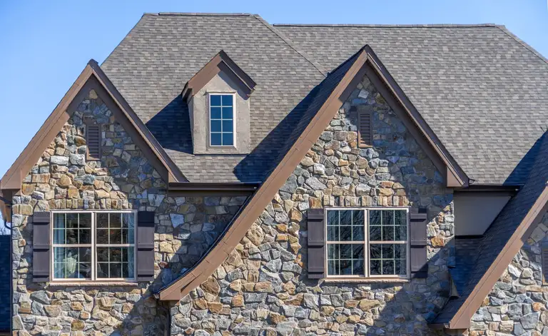 Stone home with a completed grey roof